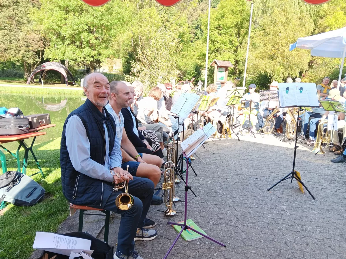 Mitglieder des Posaunenchors unter sonnigem Himmel freuen sich auf ihren Einsatz