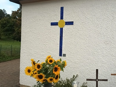 Glaskreuz an der Friedhofskapelle Trebgast mit Sonnenblumen